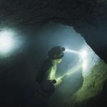 Bergarbeiter Mit Helm Und Stirnlampe Bohren Löcher In Einen Stollen, Umgeben Von Dichtem Staub