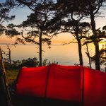 Rotes hilleberg zelt an der küste von gotalnd schweden beim sonnenuntergang