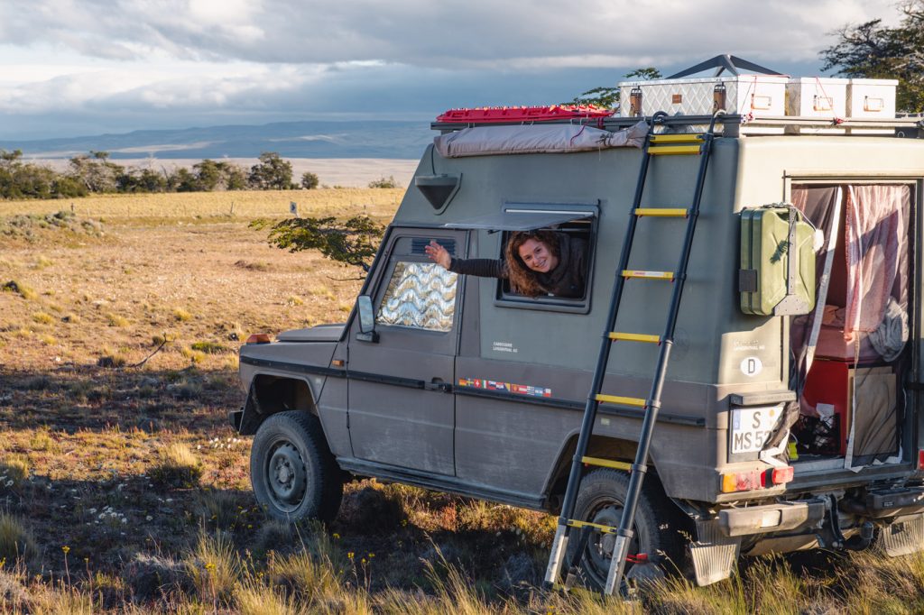 EIn Puch Camper beim Wildcampen in Patagonien, eine Frau schaut aus dem Fenster